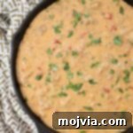 Creamy Smoked Queso 11 smoked queso dip in a skillet topped with fresh cilantro