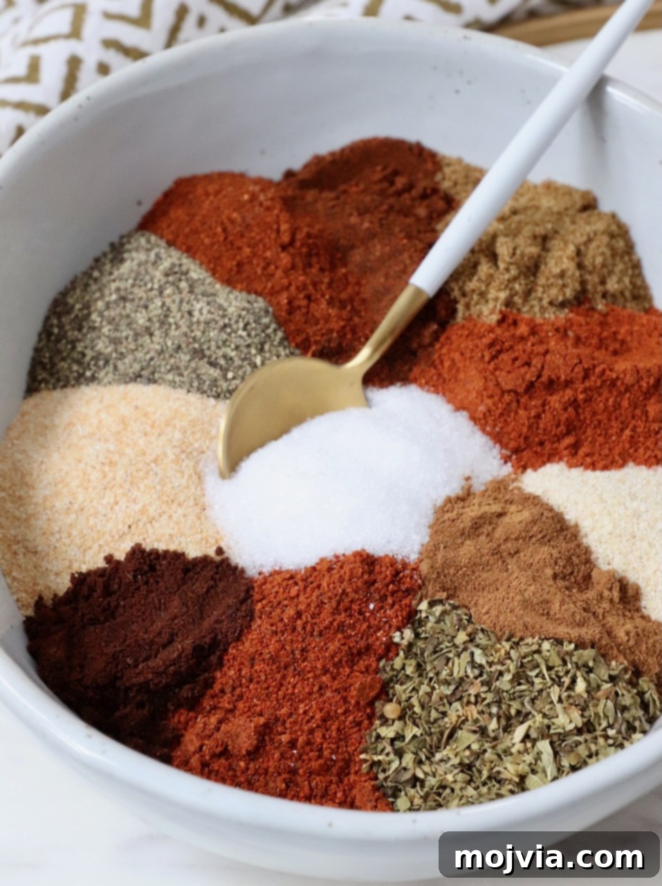 Ultimate Birria Flavor Mix 2 dried herbs and spices separated in a bowl with a spoon