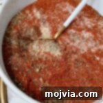 dried herbs and spices mixed together in a bowl with a spoon