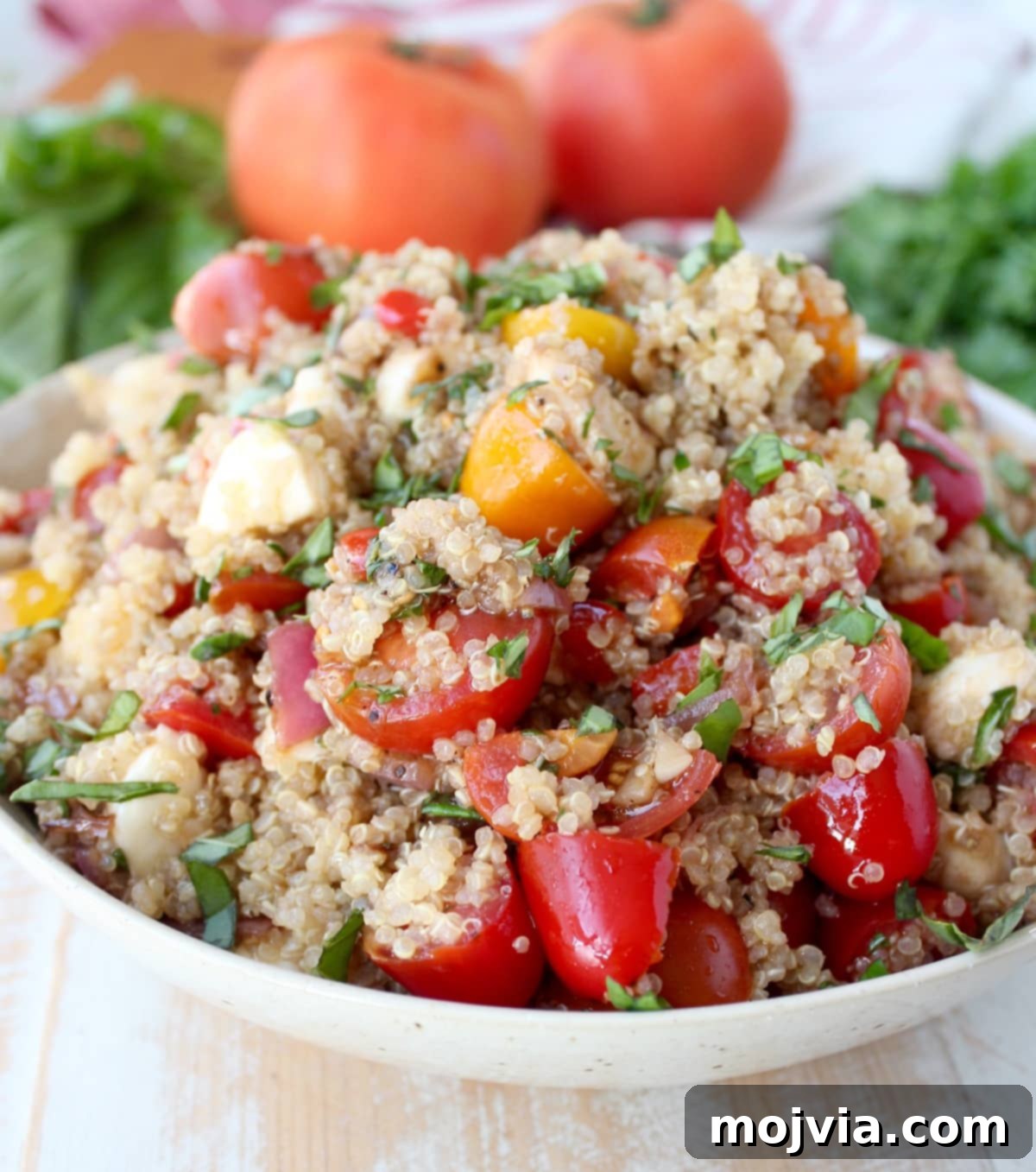 A vibrant Quinoa Caprese Salad served beautifully in a crisp white bowl, showcasing its fresh ingredients.