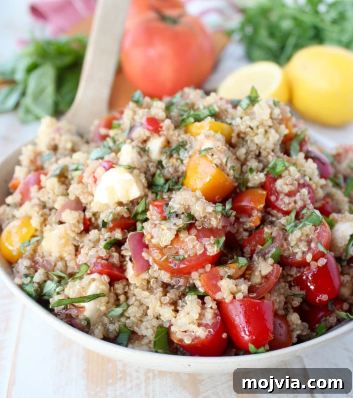 The final Quinoa Caprese Salad, beautifully mixed and presented in a white serving bowl.