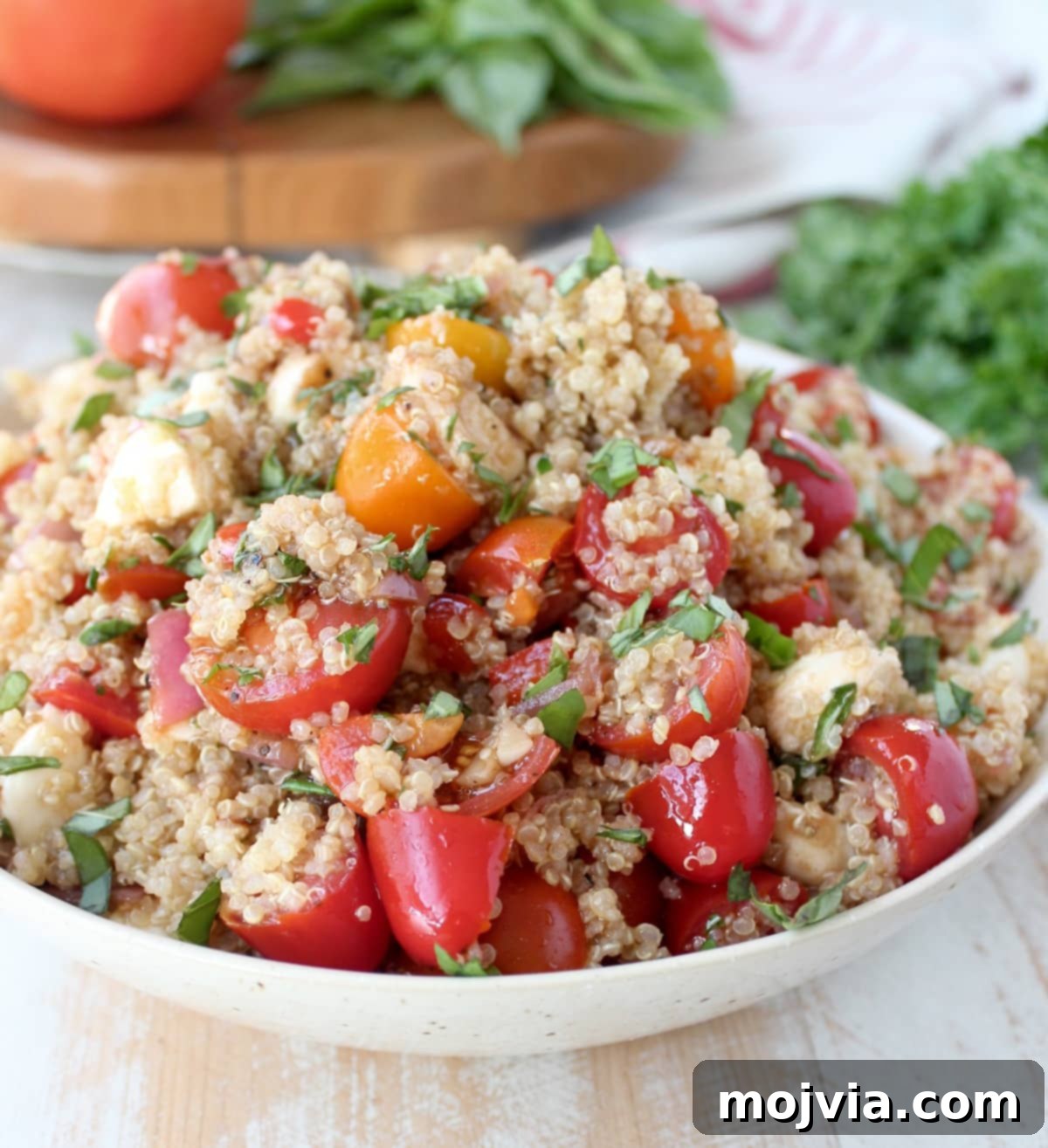 A close-up shot of the Quinoa Caprese Salad in a white bowl, highlighting its texture and fresh ingredients.