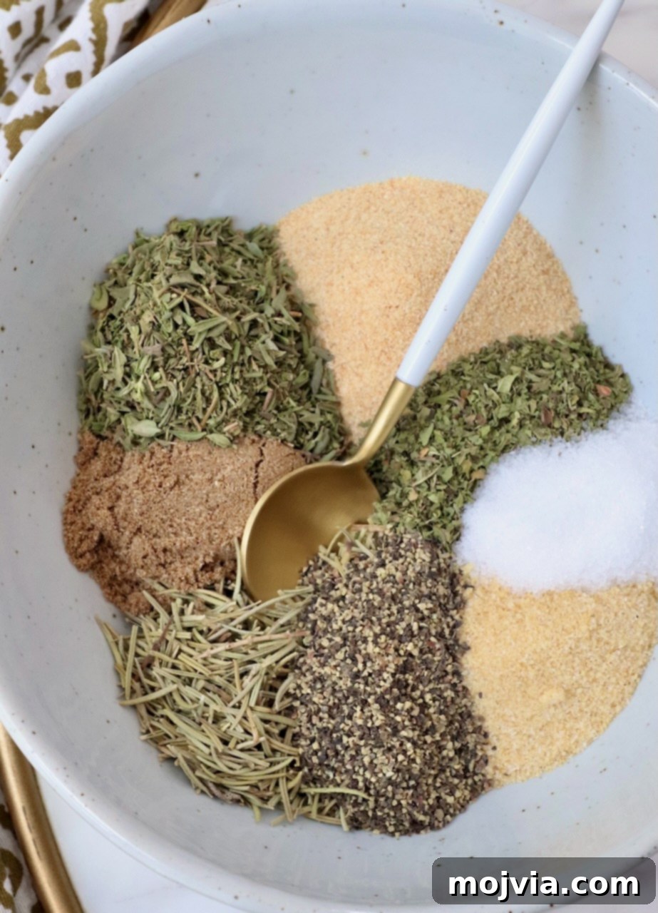 Perfect Lamb Rub 2 dried herbs and spices separated in a bowl with a spoon, highlighting the key ingredients for lamb seasoning