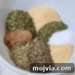 Perfect Lamb Rub 6 dried herbs and spices separated in a bowl for lamb seasoning
