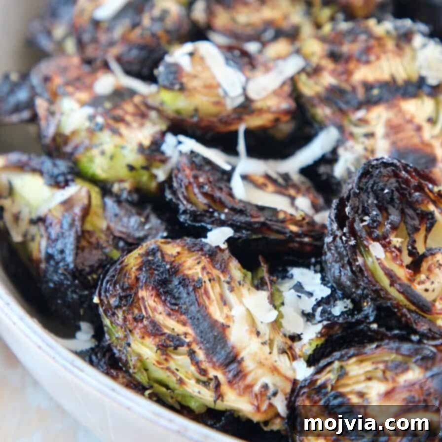 Perfectly grilled Brussels sprouts served in a bowl, generously topped with grated Parmesan cheese, creating a delightful and healthy side dish.