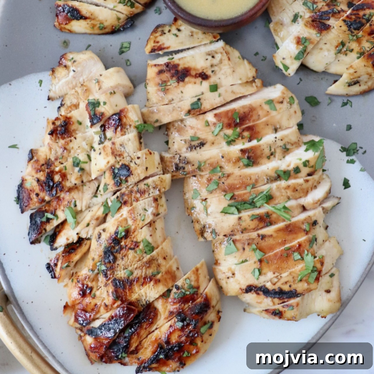 A plate showcasing tender, perfectly sliced grilled chicken, ready to be enjoyed as a main course or incorporated into a variety of dishes.