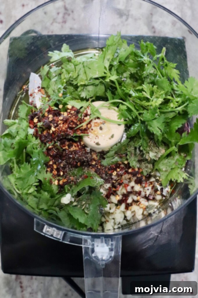 fresh cilantro with spices and garlic in a food processor