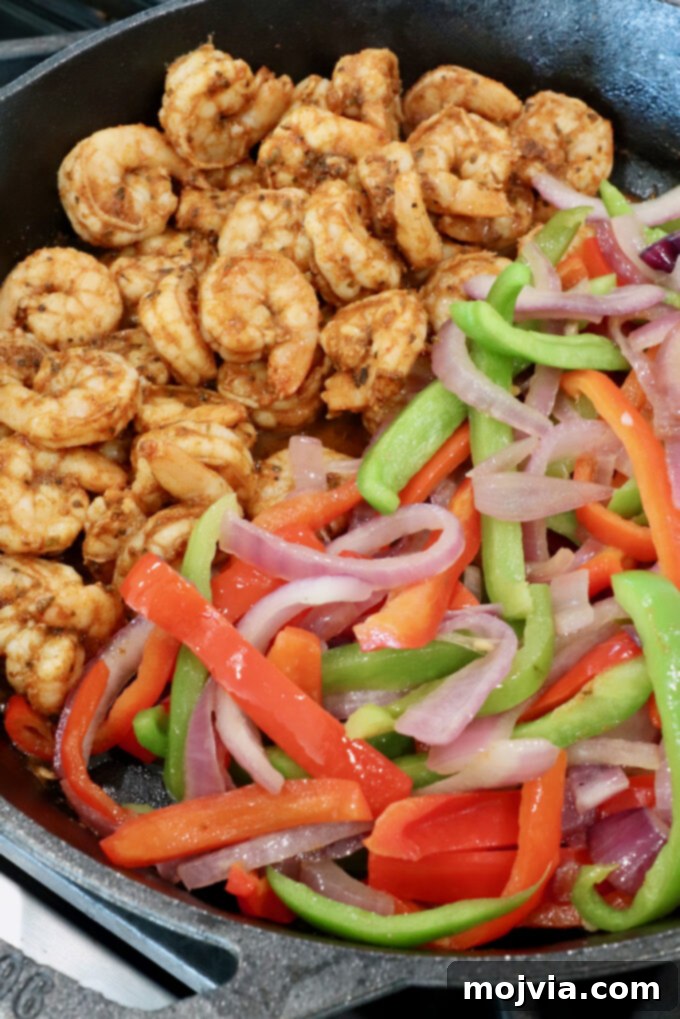 Sizzling Shrimp Fajita Feast 9 seasoned cooked shrimp in a cast iron skillet with sliced bell peppers and onions