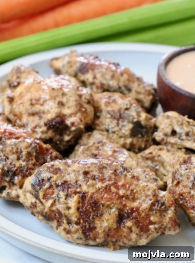 Bold Louisiana Cajun Sauce 4 cooked chicken wings tossed in a creamy sauce on a plate