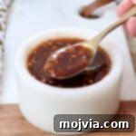Homemade General Tso sauce in a small bowl with a spoon, ready to serve.