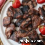 Grilled steak bites on a plate with cherry peppers