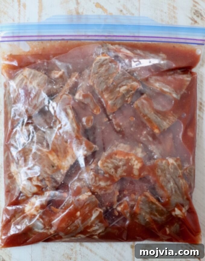 Steak tips marinating in a large plastic zipper bag with the unique marinade