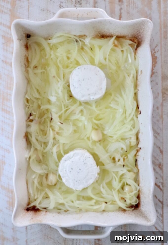 Golden French Onion Boursin Pasta 5 sliced caramelized onions in a white casserole dish with two rounds of boursin cheese