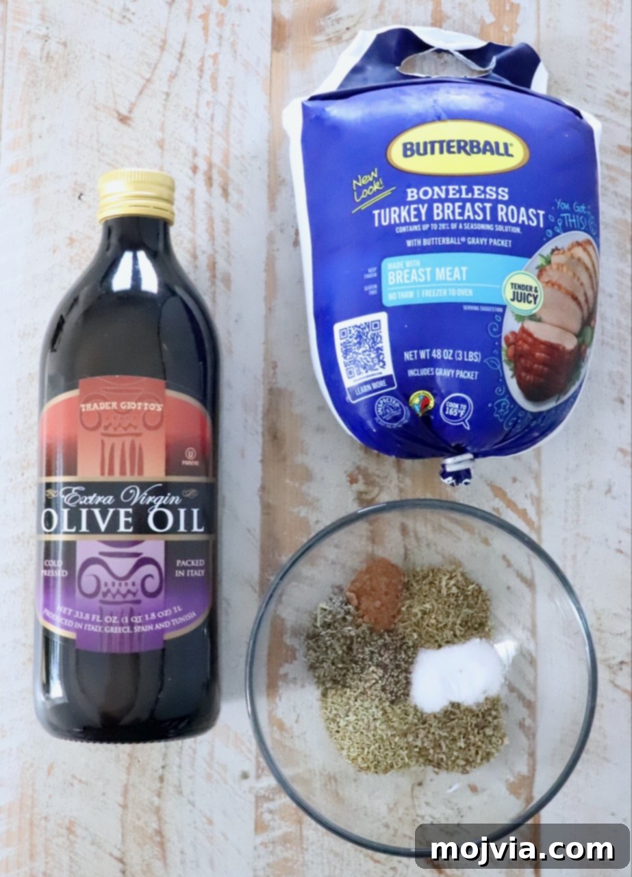 Perfect Air Fried Turkey Breast 3 Bottle of olive oil, a package of boneless turkey breast roast, and a glass bowl with mixed spices, all on a light wooden surface.
