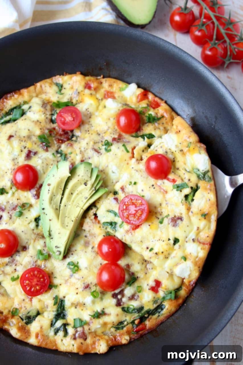 Savory Spinach and Bacon Frittata 4 Slice being taken out of a frittata in the skillet
