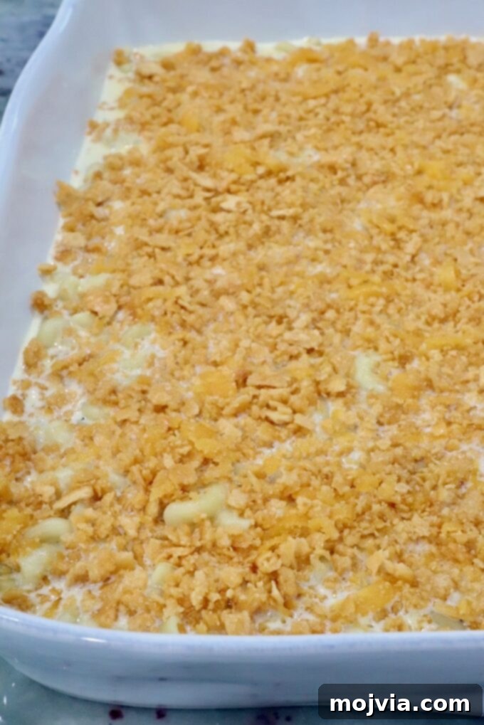 Golden Cheez-It Mac and Cheese Bake 11 A white baking dish filled with creamy macaroni and cheese is topped with a golden, crumbly crus