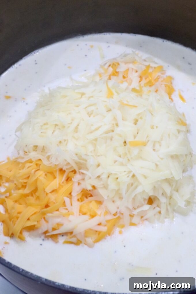 Golden Cheez-It Mac and Cheese Bake 6 Shredded cheese melting into a creamy white sauce in a pot.
