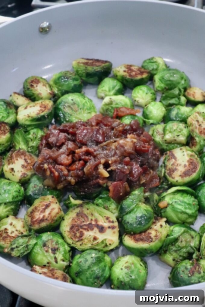 Sticky Bacon Brussels Sprouts 6 Pan-seared Brussels sprouts, halved and caramelized, surround a rich, savory bacon and onion jam in a gray skillet