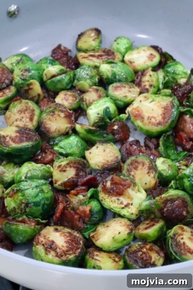 Sticky Bacon Brussels Sprouts 7 Caramelized Brussels sprouts with crispy, browned edges, mixed with bacon jam in a skillet