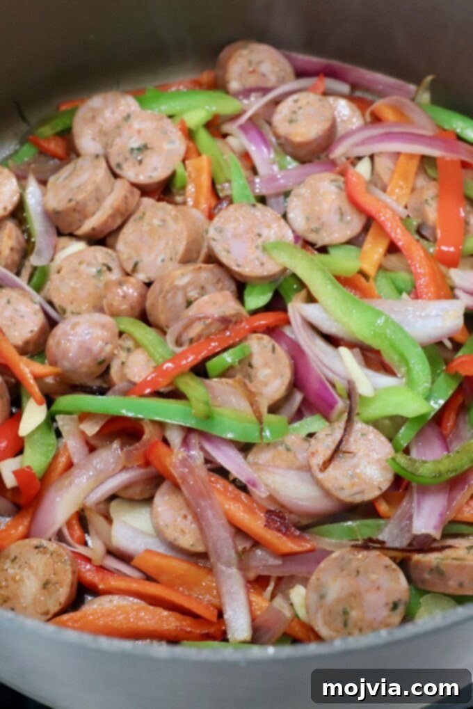 Classic Italian Sausage and Peppers 4 Sliced Italian sausage and colorful bell peppers sautéing in a large skillet.