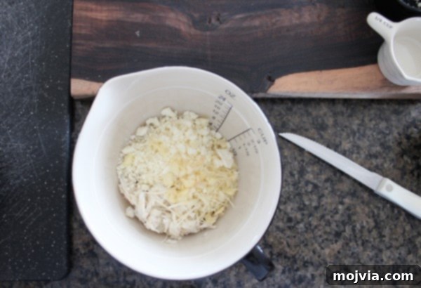 Close-up of cooked couscous and fresh lump crab meat combined in a clear mixing bowl, ready for the next steps in the Mediterranean stuffed mushroom recipe.