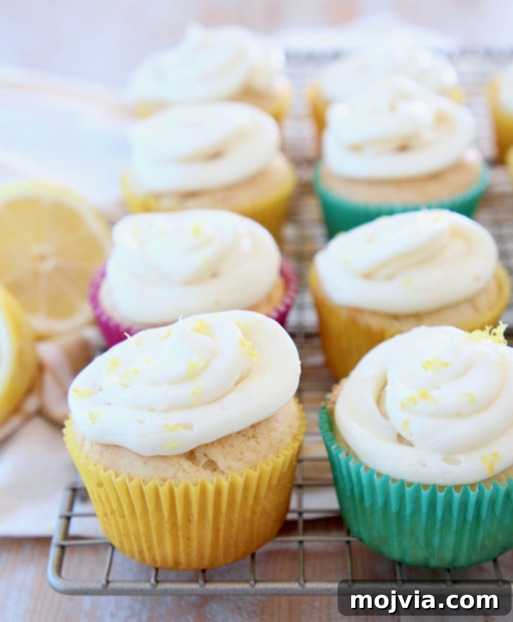 Zesty Lemon Buttercream Cupcakes 2 Lemon cupcakes with cream cheese frosting sitting on wire rack