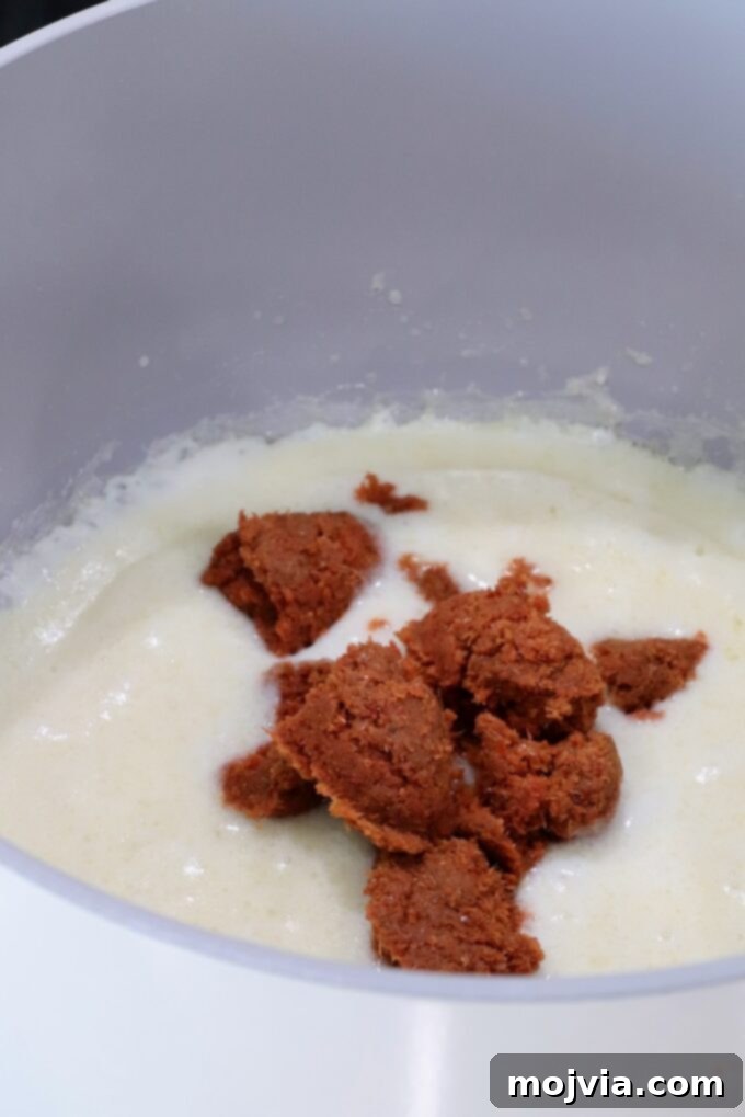 Curried Cheese Dip 4 Creamy roux sauce in a pot topped with spoonfuls of red curry paste.
