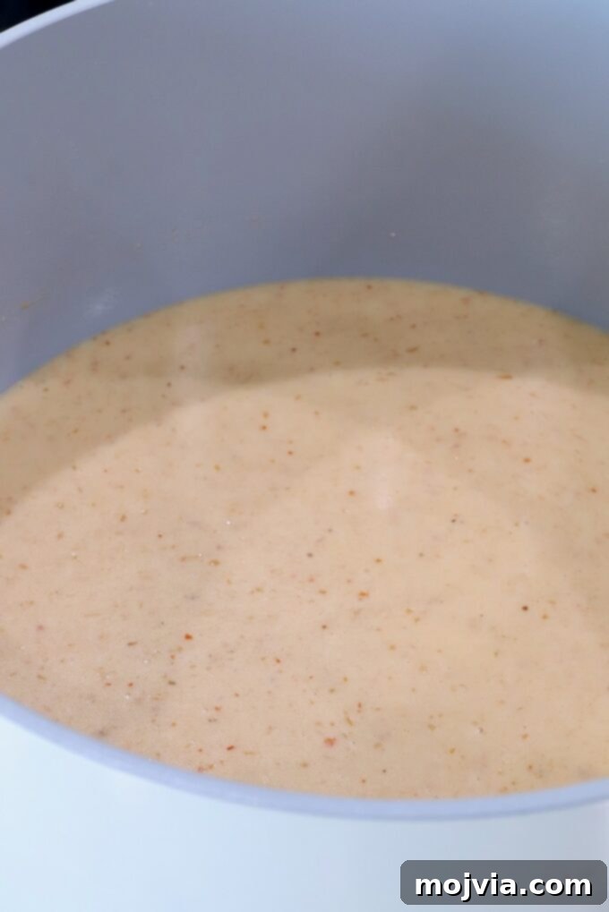 Curried Cheese Dip 5 Creamy red curry sauce in a pot.