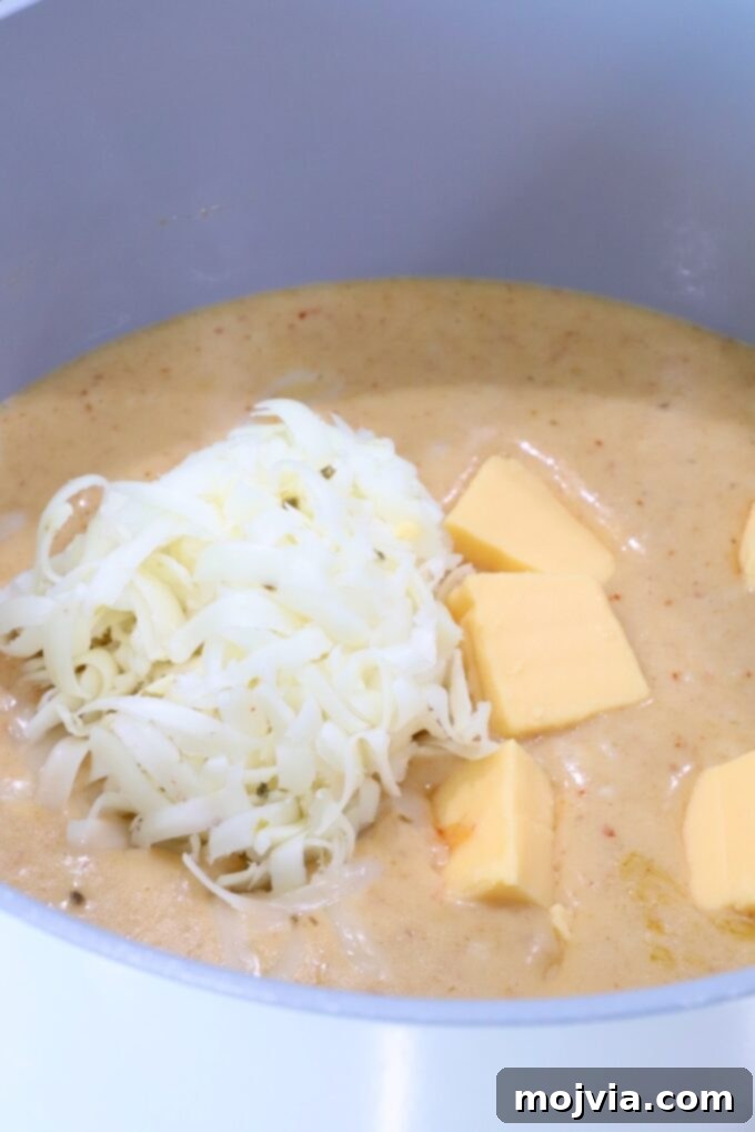 Curried Cheese Dip 6 Creamy red curry sauce in a pot with cubed Velveeta cheese and shredded pepper jack cheese.