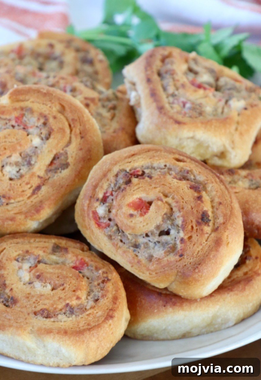 Sausage Cream Cheese Crescents 2 Golden brown sausage cream cheese crescent rolls on a plate