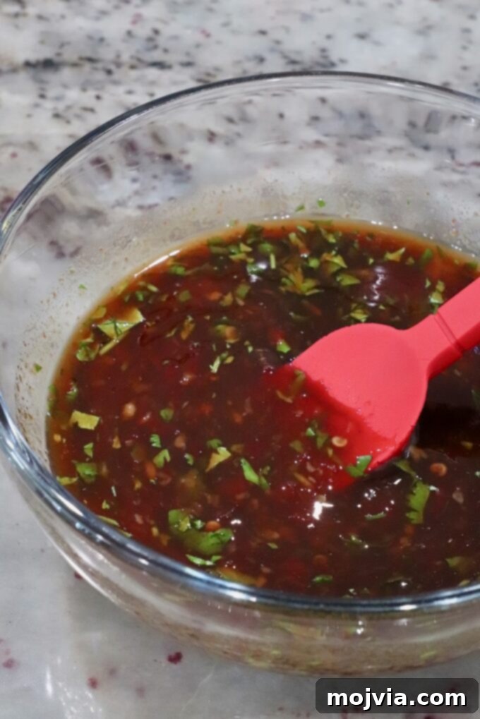 Thai Chicken Delight 5 Thai chili glaze in a glass bowl with chopped herbs.
