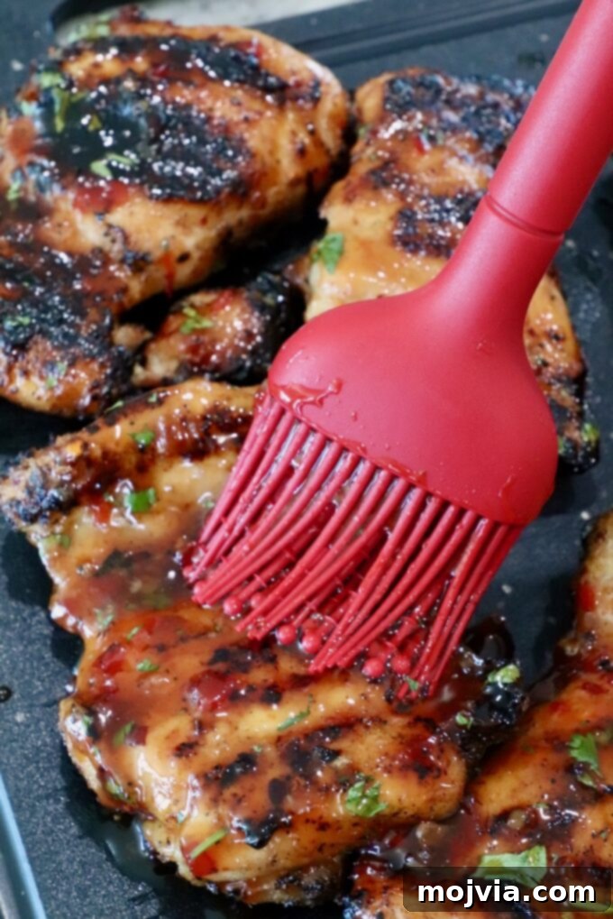 Thai Chicken Delight 7 Brushing the Thai chili glaze on grilled chicken.