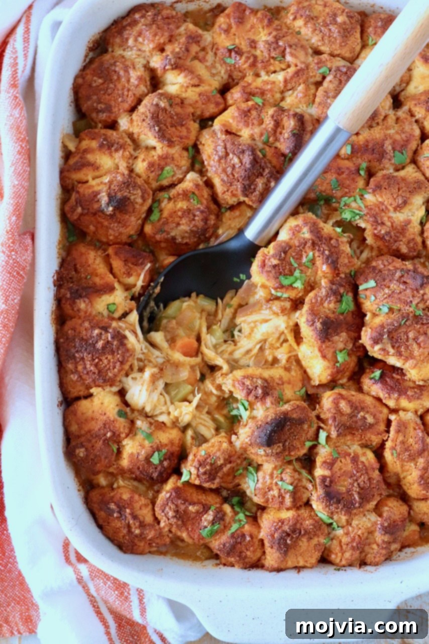 Buffalo Chicken Pot Pie
Savory Buffalo Chicken Pot Pie Delight 2 Golden-brown biscuits topped with herbs cover a hearty chicken and vegetable pot pie in a white dish. A spoon reveals the warm, savory filling.