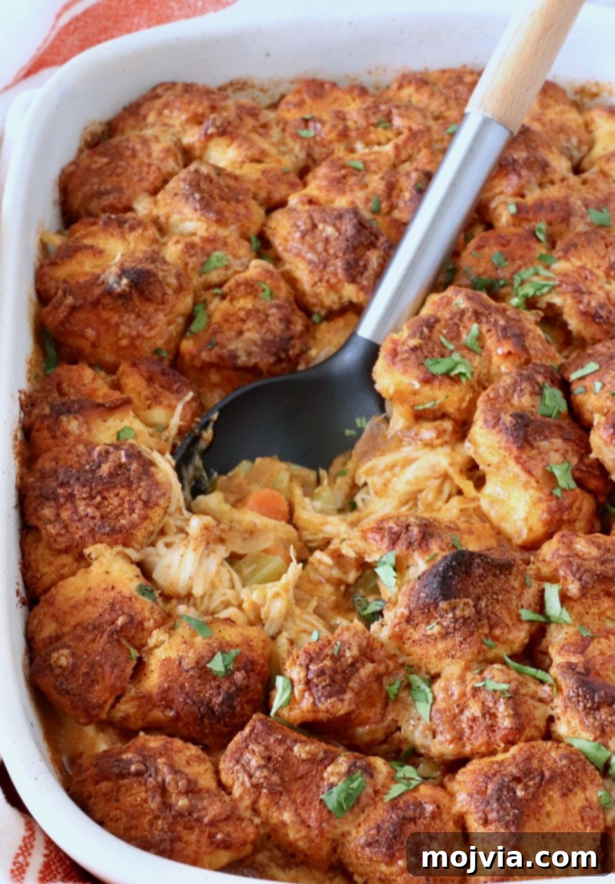 Buffalo Chicken Pot Pie
Savory Buffalo Chicken Pot Pie Delight 13 Close-up of a baked buffalo chicken pot pie topped with golden biscuit pieces. Garnished with fresh herbs, a serving spoon rests in the dish.