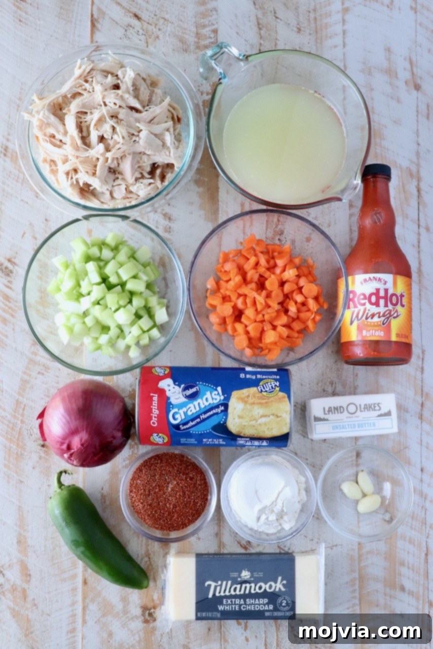 Buffalo Chicken Pot Pie
Savory Buffalo Chicken Pot Pie Delight 3 Overhead view of cooking ingredients: shredded chicken, broth, diced celery, carrots, hot sauce, onion, jalapeño, biscuits, butter, seasonings, and cheddar cheese