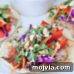 Pad Thai Tacos 9 Close-up of pad thai tacos with vibrant toppings like red peppers, carrots, purple cabbage, and cilantro