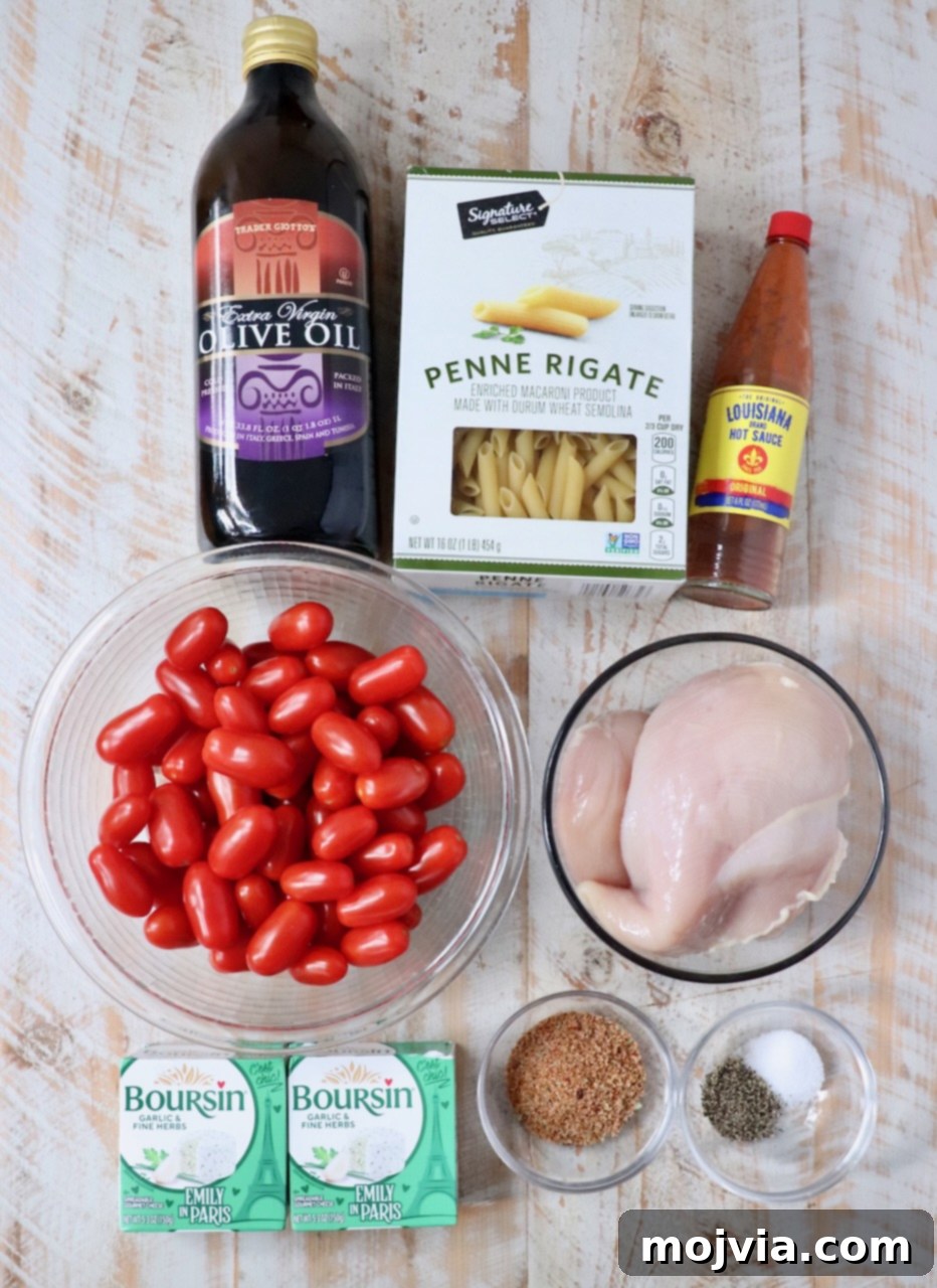 Ingredients for Creamy Cajun Chicken Pasta arranged on a wooden surface.