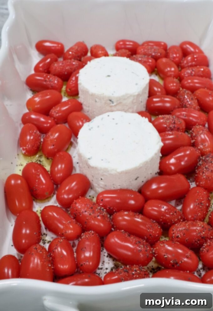 Two rounds of Boursin cheese in a baking dish surrounded by cherry tomatoes.