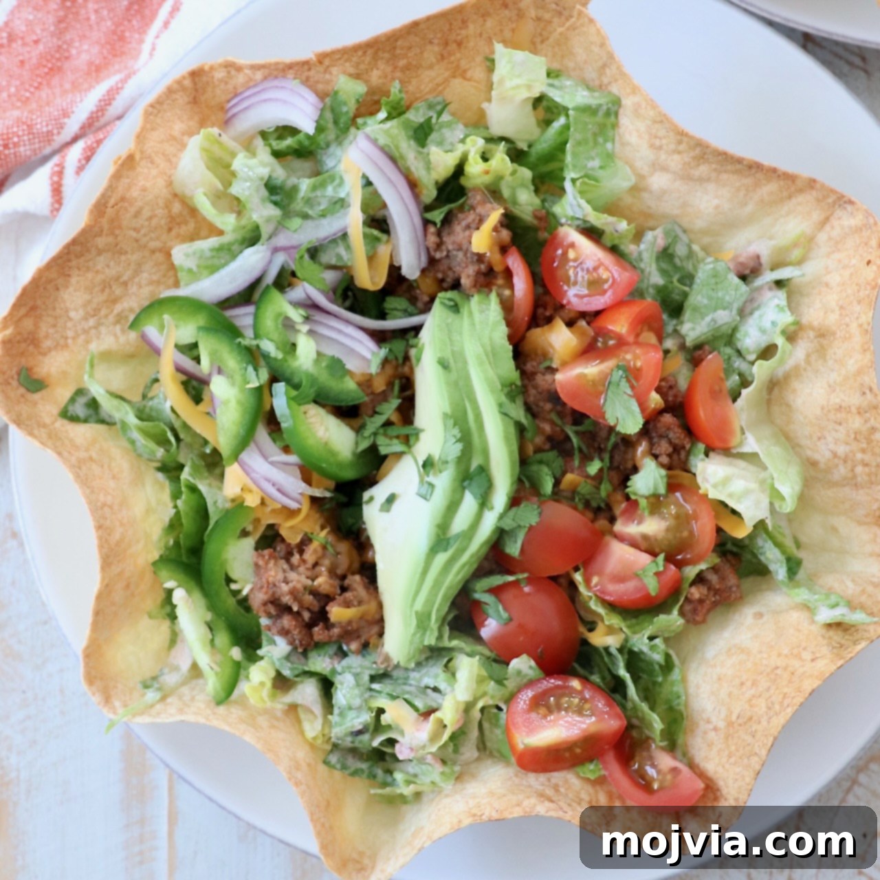 taco salad in tortilla shell on plate