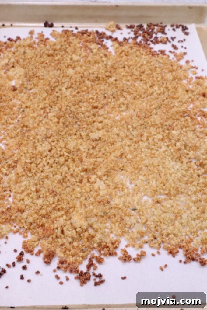 Bayou Blackened Chicken Salad 8 Cooked crispy quinoa spread out evenly on a parchment-lined baking sheet, cooling and ready for use.
