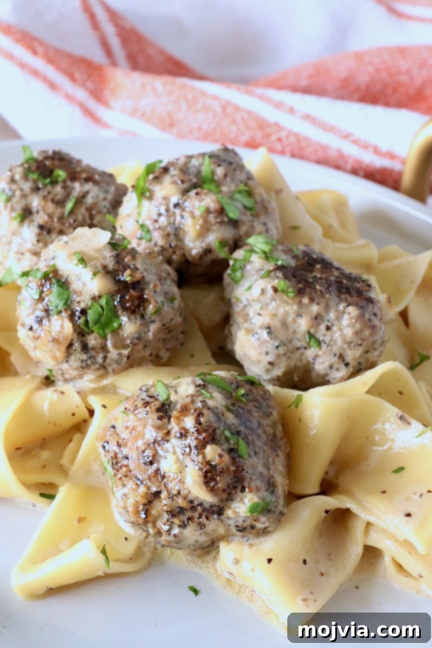 Creamy Peppercorn Meatballs 12 meatballs au poivre on top of pappardelle pasta on a plate