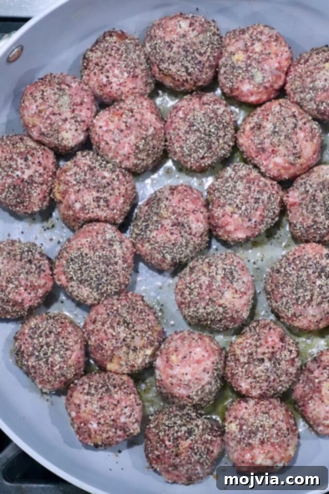 Creamy Peppercorn Meatballs 6 pepper coated raw meatballs in a skillet