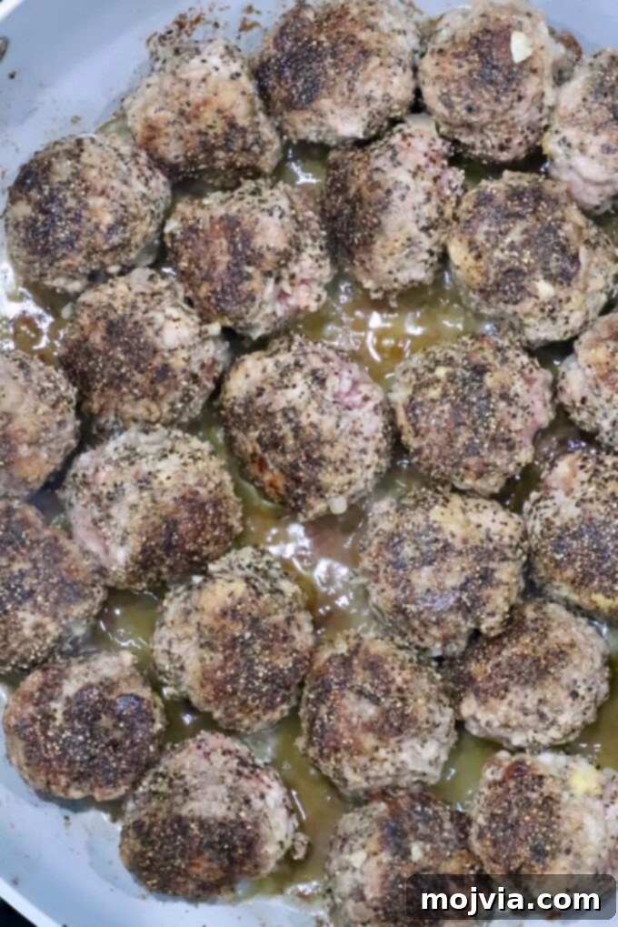 Creamy Peppercorn Meatballs 7 cooked meatballs in a skillet