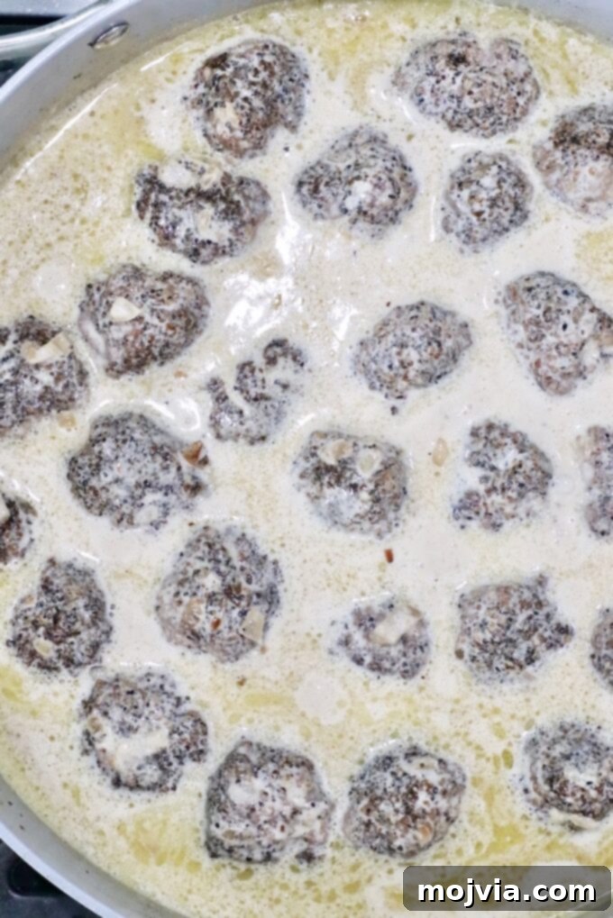 Creamy Peppercorn Meatballs 10 meatballs in a pan sauce in a skillet