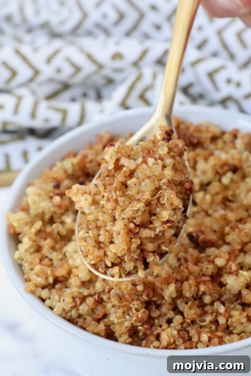Golden Quinoa Crunch 2 Golden crispy quinoa in a spoon lifted out of a bowl, showcasing its appealing crunchy texture.