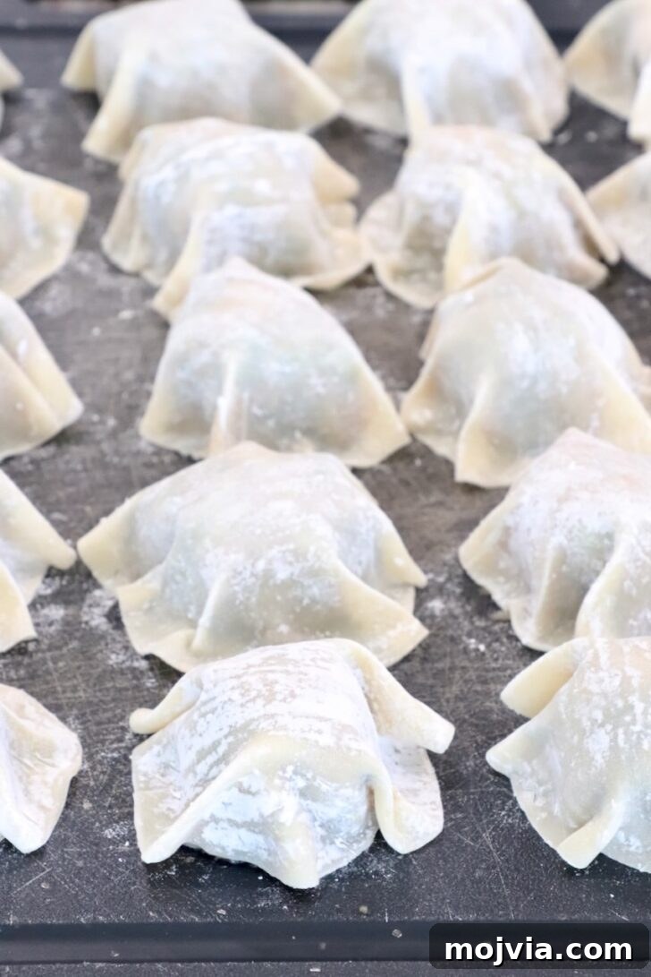 Thai Basil Chicken Dumplings: Flavorful Asian-Style Potstickers 9 prepared blanket dumplings on a cutting board
