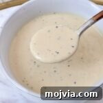 Miso Caesar Dressing Recipe: Creamy Umami Salad Dressing 10 miso caesar dressing in a bowl with a spoon dipping the dressing out of the bowl