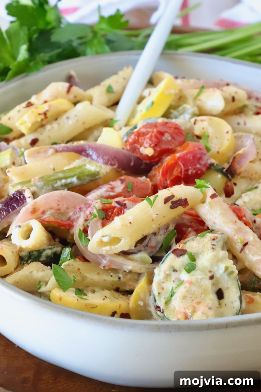 Creamy Boursin Pasta Primavera with Spring Vegetables 2 creamy pasta primavera in a bowl with a fork, with fresh parsley in the background