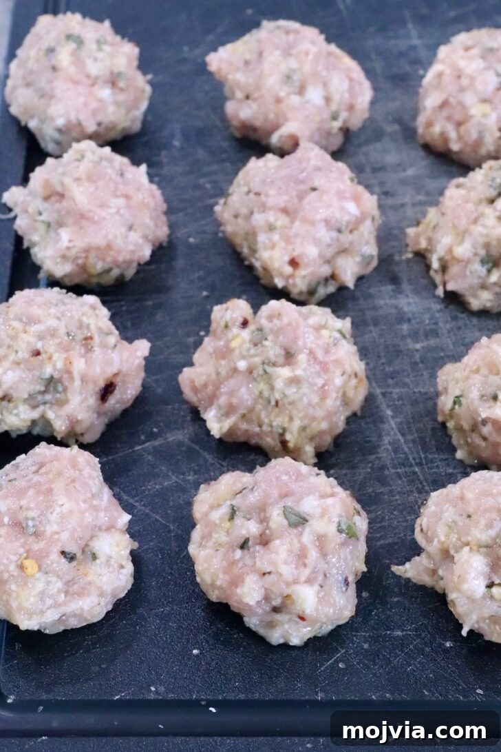 raw chicken meatballs on a cutting board