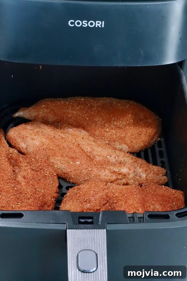 Chipotle Honey Chicken Tacos Made in the Air Fryer 7 raw, seasoned chicken breasts in an air fryer basket